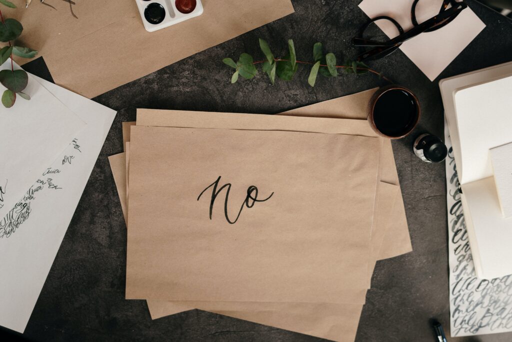 "No" written in cursive on brown parchment paper