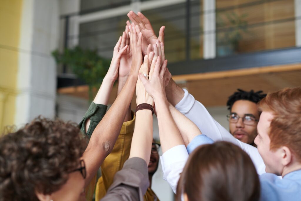 A team hi-fiving each other, instilling a sense of belonging
