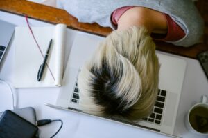 Someone falling asleep at the computer as a result of email fatigue