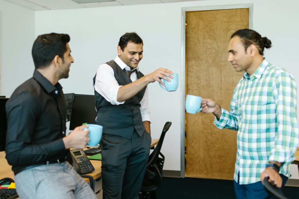 3 employees cheering each other with their cups of coffee